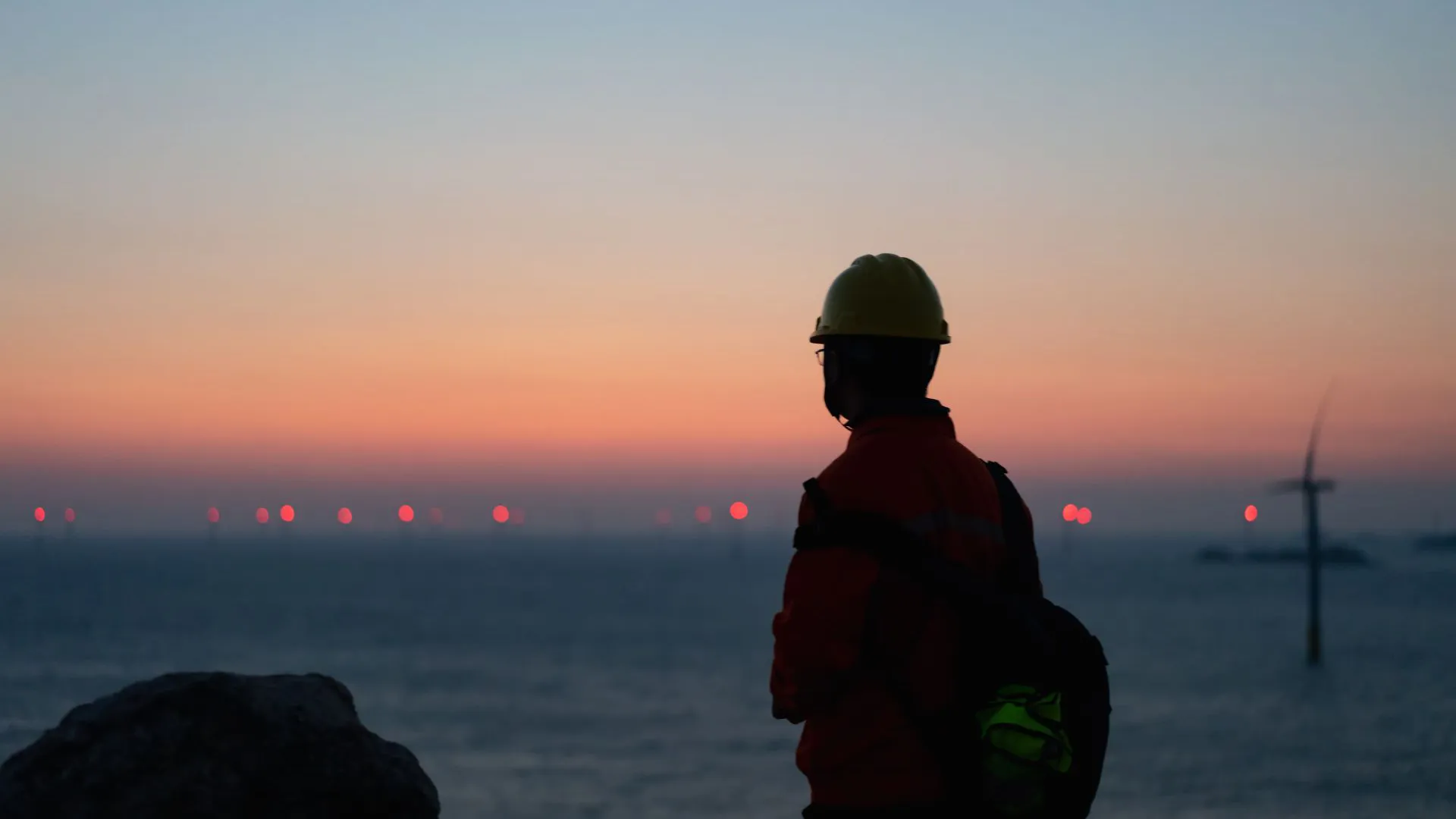 Silhouette of a worker out at an offshore wind farm